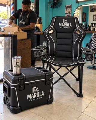 Kit com cadeira, cooler e copo térmico personalizados para uma barbearia, montado no balcão